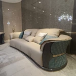Cream Curved Leather Sofa with Dark Green Fan-Stitched Panels and Laced Edge Details